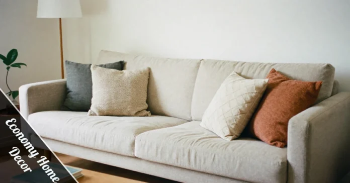 Economy home decor living room with thrifted sofa, DIY gallery wall, throw pillows & budget-friendly plant decorations.