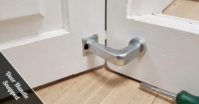 Close-up of a door handle snapped off a white door with spindle hole visible and a flathead screwdriver on the floor nearby.